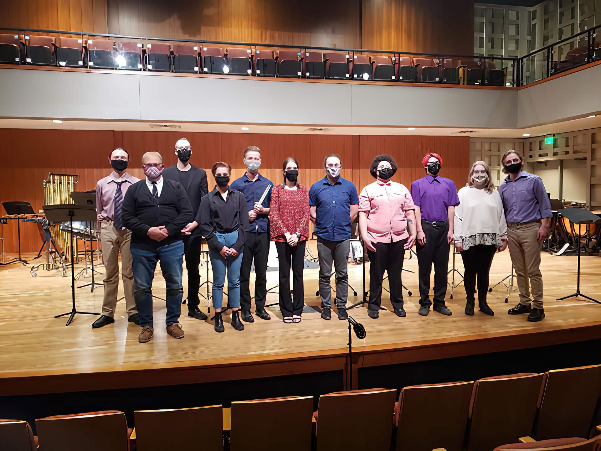 Dr. Scott Brickman first live performance in U.S. Performers stand on stage posing for a group photo.