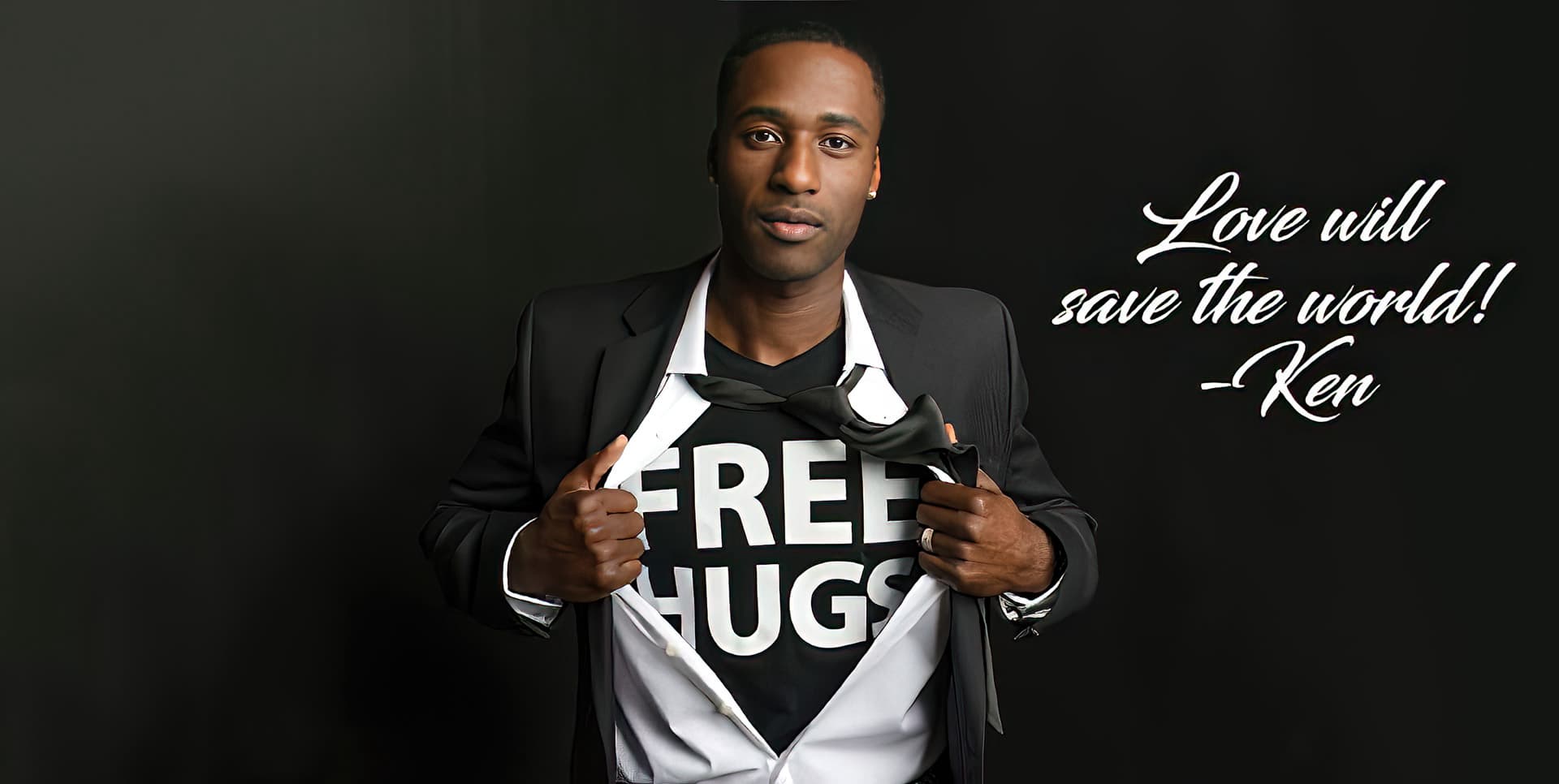 Motivational Spealer Ken E. Nwadike, Jr. wearing a t-shirt under his suit that reads, "free hugs."