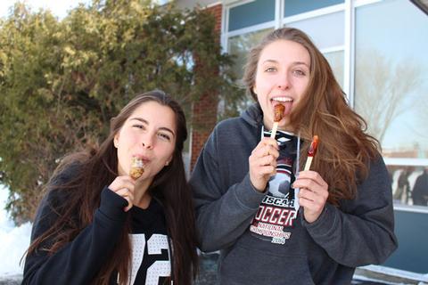 UMFK students Catherine Bruno, from Montreal, Quebec, and Kendra Freund, from Delhi, Ontario, enjoying the maple taffy on the snow.