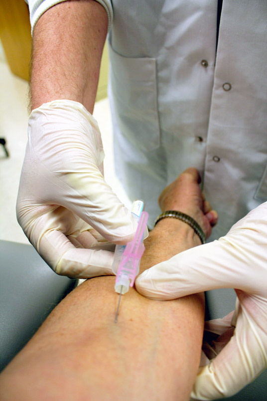 a phlebotomist drawing blood for testing