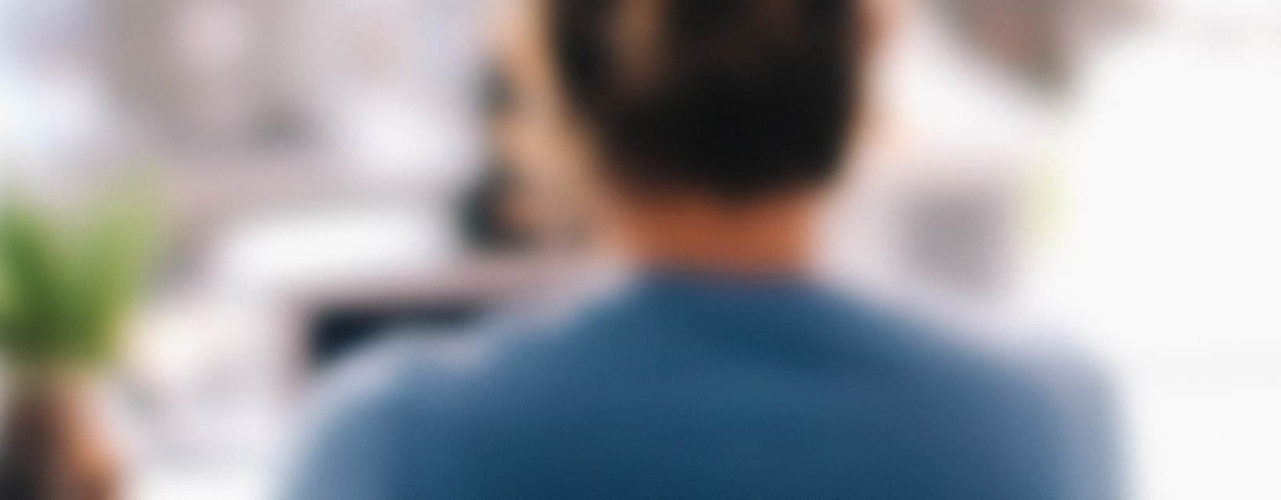 blurred photo of a woman working at her desk in an office