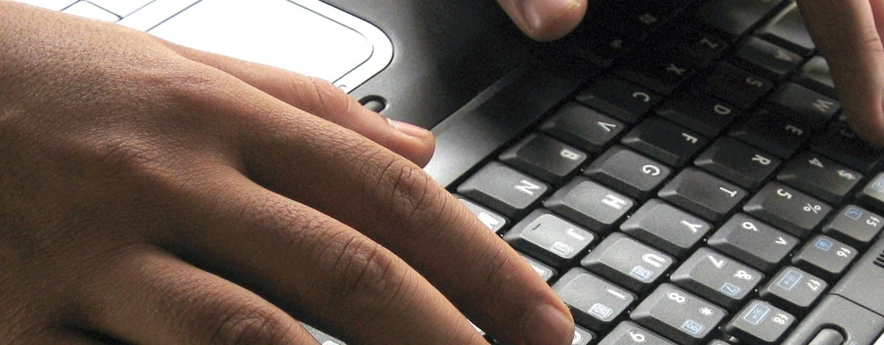 User Typing on Laptop