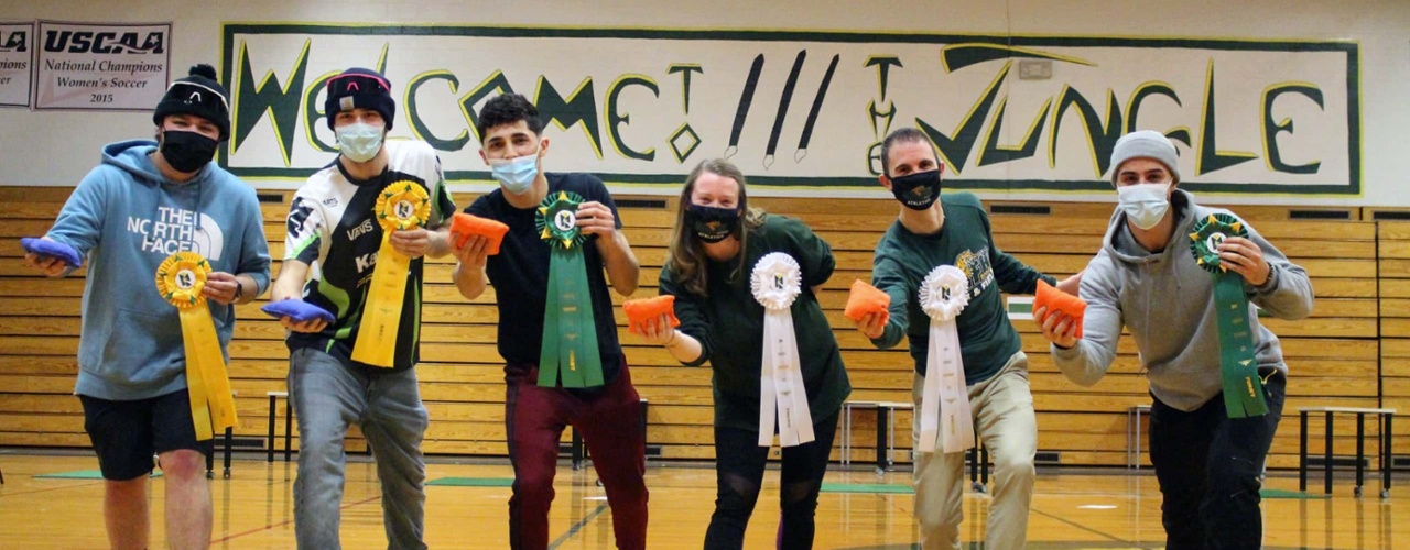 award winners of a cornhole tournament pose with their awards