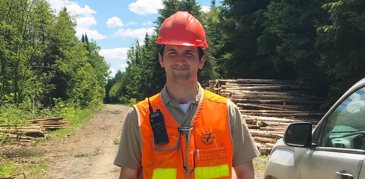 a UMFK forestry alumnus and seven islands forester poses next to his pickup truck