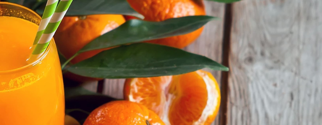 Glass of Orange Juice With Oranges Around it