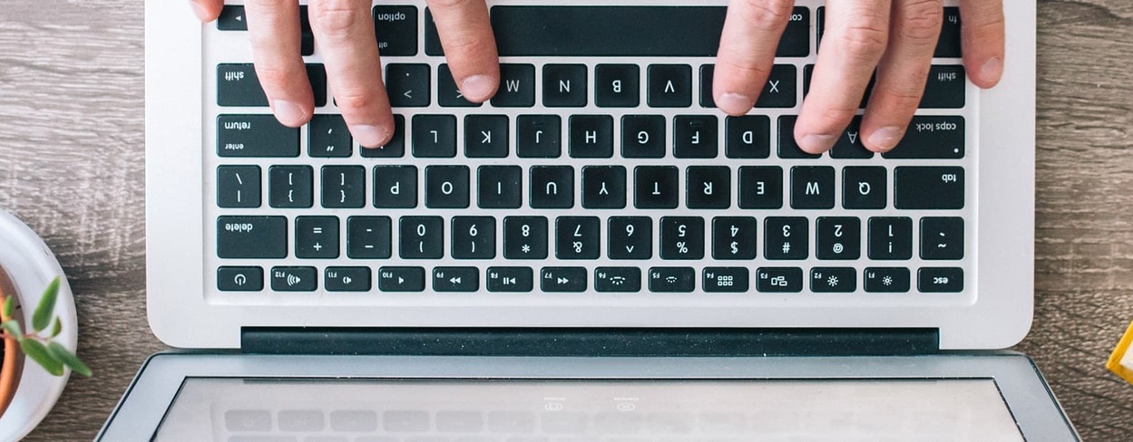 Photo from Above of Someone Working on a Laptop