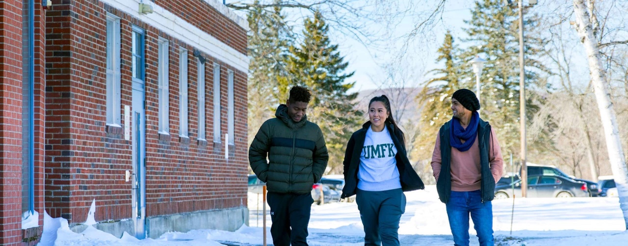 three umfk students walking outdoors in the middle of winter