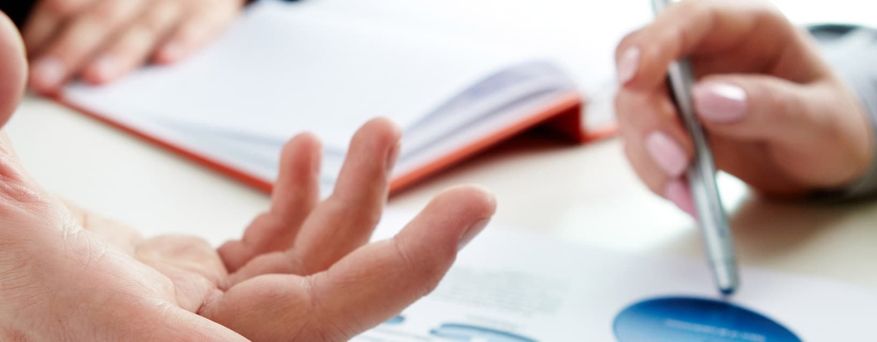 closeup of two people working together on a report