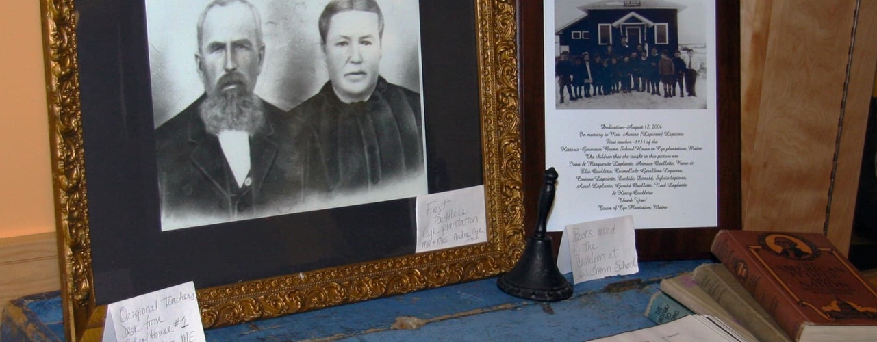 photo, drawing, books, and hand-held school bell on display during the Beatrice Craig exhibit at the Acadian Archives